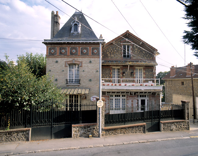 Vue d'ensemble de la maison composée de deux corps de bâtiments juxtaposés. Chacun porte un décor de céramique (cabochons et personnages dans des niches).
