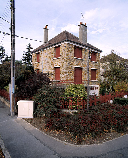 Vue d'ensemble de la maison à logements multiples située au 93, avenue du 18 Avril, à l'entrée de la rue du Dr Calmette. Cette rue est bordée d'une série de maisons identiques à celle-ci.