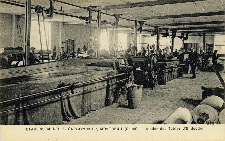 Atelier des tables d'enduction de l'usine de toiles cirées Caplain, 29, rue de l'Ermitage, vers 1920. Carte postale. (Musée de l'histoire vivante, Montreuil. 7 F 80)