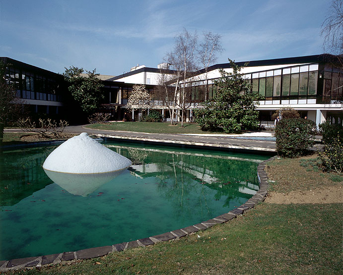 Vue d'ensemble des premiers bâtiments de l'usine ainsi que des aménagements paysagers. Au premier plan, sur le plan d'eau, est placé le Sein, oeuvre du sculpteur César.