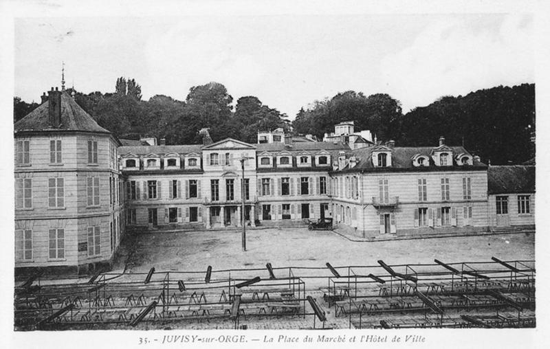 Façade antérieure de l'édifice avec la place du marché au premier plan.