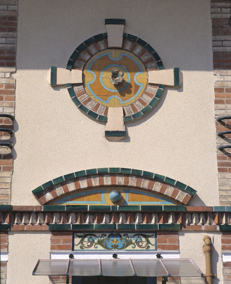 Détail du décor de céramique situé au-dessus de la porte d'entrée.