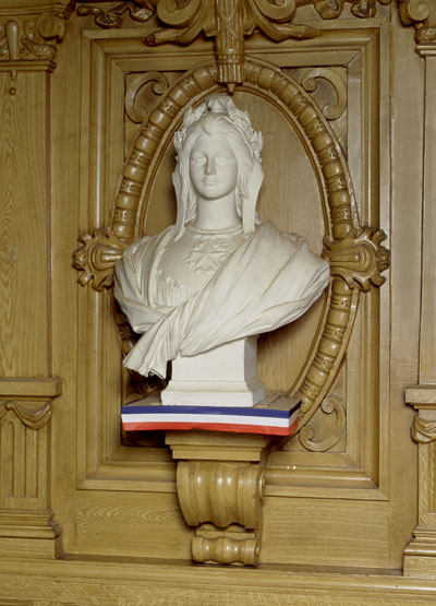 Vue de face du buste situé au-dessus de la cheminée du mur ouest de la salle des fêtes.