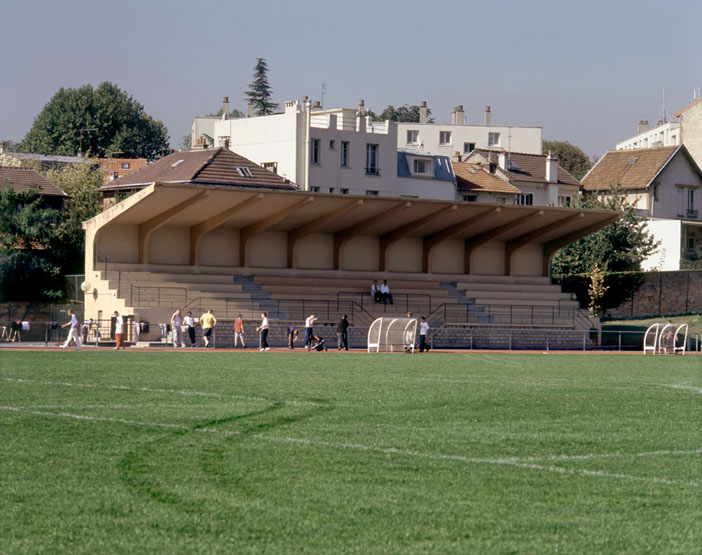 Vue de la tribune depuis la pelouse du terrain de football.