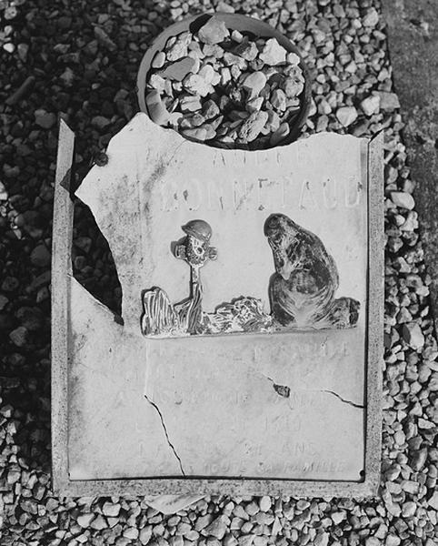Détail d'une tombe du carré militaire (1914-1918) : silhouettes en métal découpées sur fond de pierre