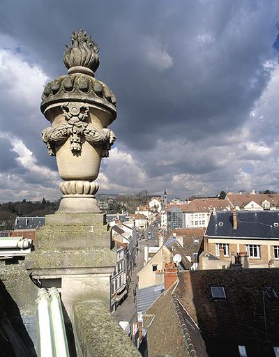 Le pot à feu couronnant l'angle nord-ouest du vaisseau central. Dans le fond, l'axe menant du faubourg Saint-Barthélemy à l'église Saint-Aspais.