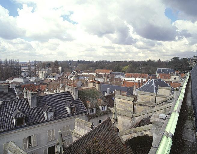 Panorama vers le sud-est, depuis la balustrade sommitale de l'église Saint-Aspais : les toits du quartier Saint-Aspais, les jardins de la Préfecture au fond. Au premier plan, arcs-boutants et toitures des chapelles sud de Saint-Aspais.