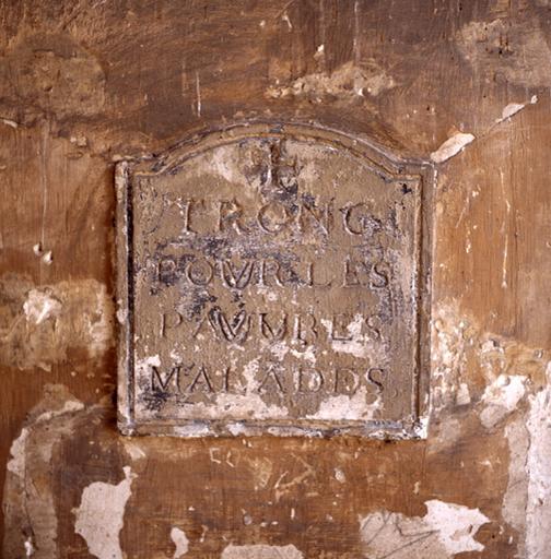 Plaque dans le cloître : 'tronc pour les pauvres malades'.