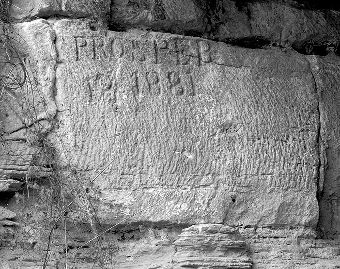 Ancienne carrière transformée en champignonnière puis désaffectée: anciens graffitis à l'entrée.