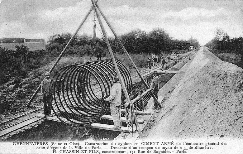 Construction du siphon en ciment armé de l'émissaire des eaux usées de Paris : descente d'un tronçon de tuyau.