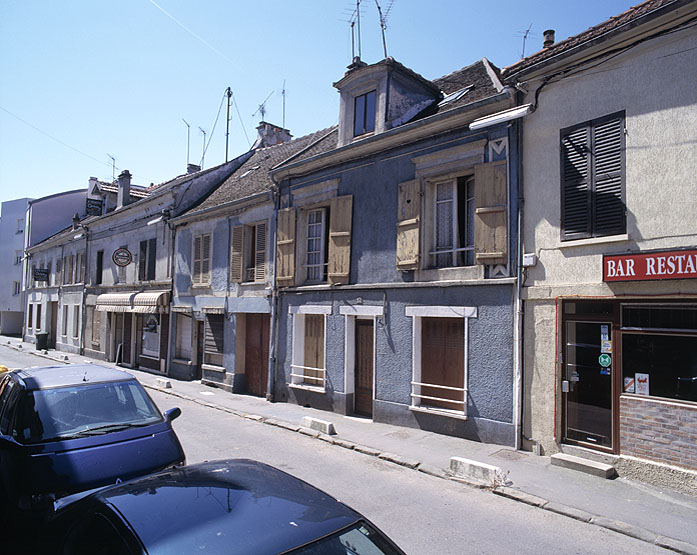 Vue perspective de la rue du côté des numéros impairs, bordée par les constructions mitoyennes du vieil Athis.