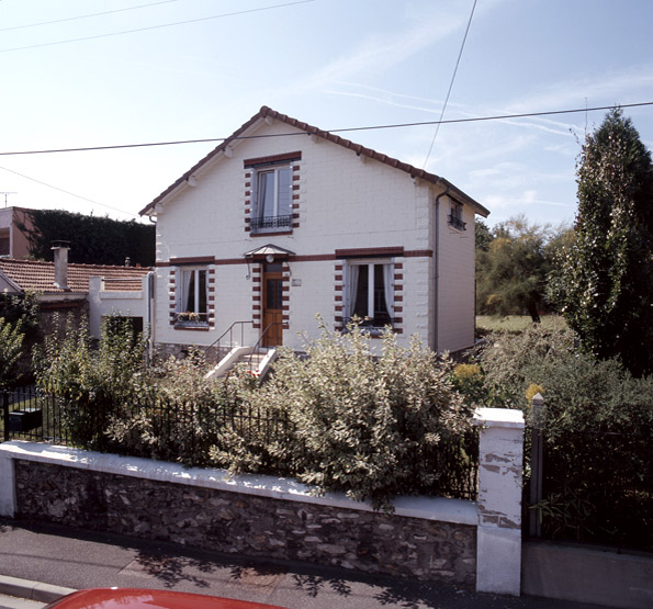 Elévations en parpaings du pavillon avec effet de bossage aux angles et à l'encadrement des baies.