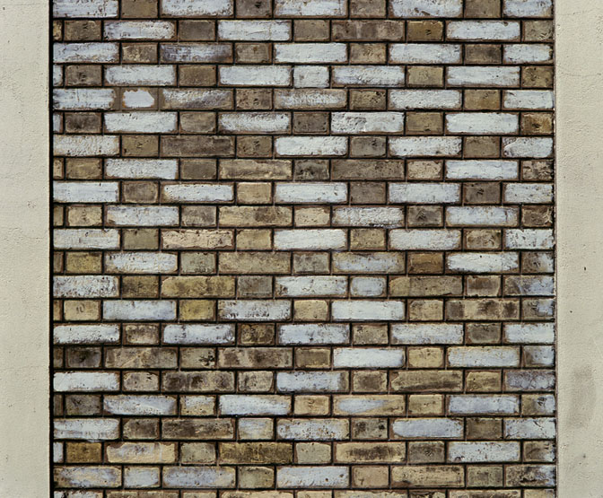 L'appareillage du mur de façade sur rue, composé de briques simples alternant avec des briques émaillées.