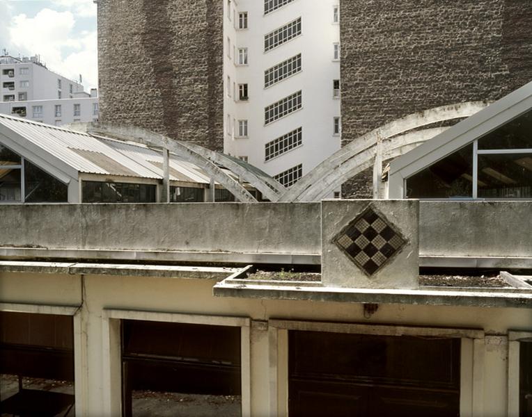 La toiture de chaque halle est suspendue par trois arceaux de béton armé inscrits dans la largeur du bâtiment.