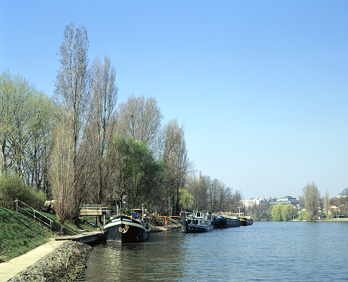 Vue des bords de Marne et de péniches prise de Champigny. Au loin on aperçoit le pavillon Baltard de Nogent.