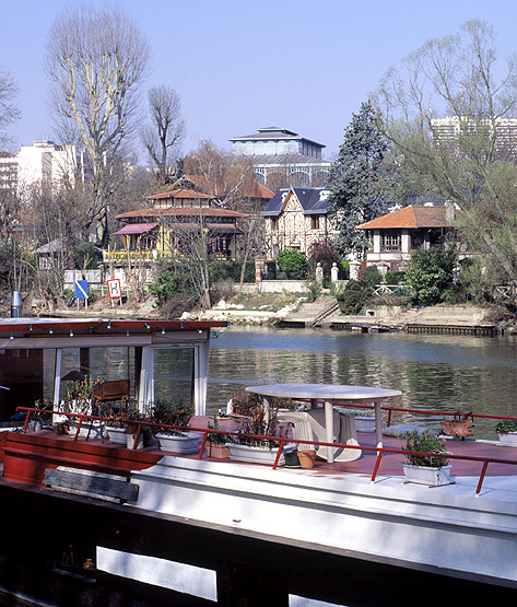 Vue prise de Champigny vers Nogent. Au premier plan une péniche amarrée, puis des maisons sur l'île de Beauté et à l'arrière plan, le pavillon Baltard.
