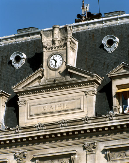 Détail du fronton couronnant la façade surmonté d'une horloge et d'une ronde-bosse évoquant le château médiéval de Beauté, comme dans les armes de la ville.