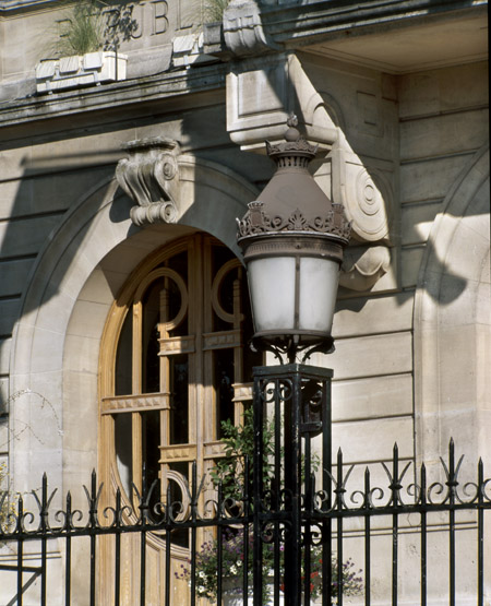 Détail d'une porte extérieure et d'une lanterne ornant la grille d'entrée.