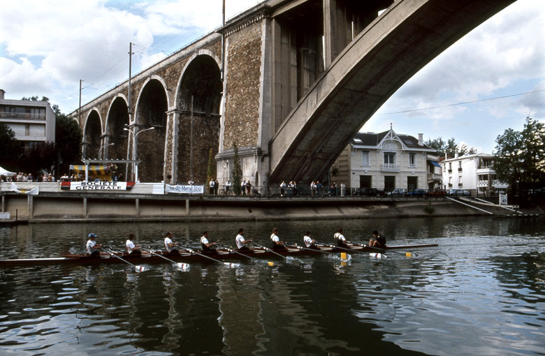 Vue depuis la rive de l'ile des Loups vers la pile du viaduc sur le quai de Nogent durant une compétation d'aviron.
