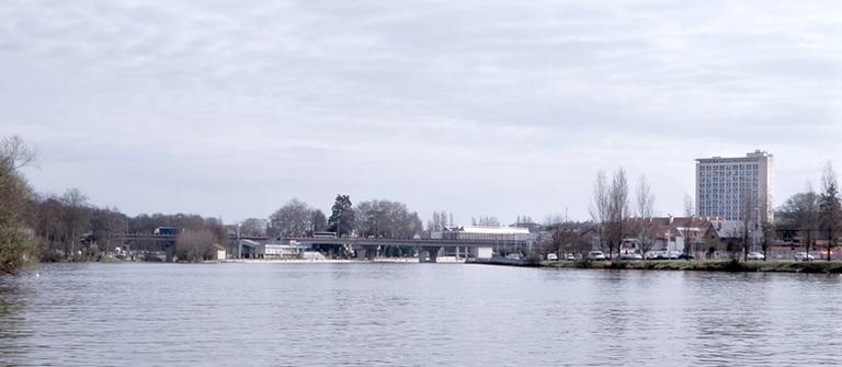 Vue générale depuis l'ouest (photographie prise depuis Le Mée, en bord de Seine). On reconnaît, de gauche à droite : la rocade, la pointe ouest de l'île Saint-Etienne, la cité administrative.