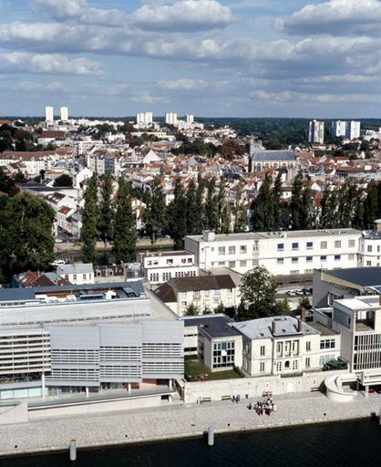 Vue panoramique, depuis le toit de la Cité administrative : au premier plan, l'île Saint-Etienne (avec la médiathèque, l'université Panthéon-Assas et la poste) ; au second plan, le quai du petit bras de la Seine et le quartier Saint-Aspais; au fond, les grands ensembles.