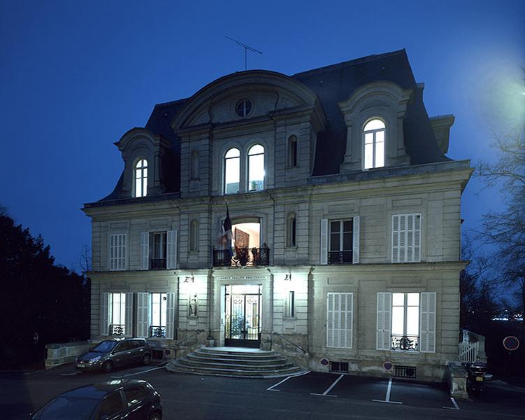 La façade antérieure de la mairie vue depuis le parc, la nuit.