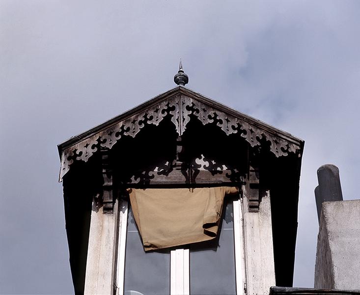 Vue du décor de la lucarne de la façade antérieure sur la rue.