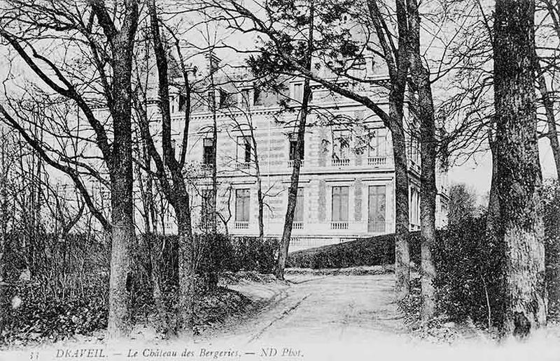 Façade latérale derrière un rideau d'arbres.