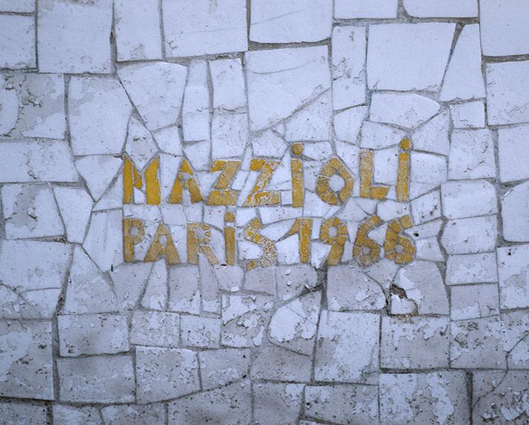 Détail de la mosaïque couvrant le pignon Ouest du gymnase : signature du mosaïste.