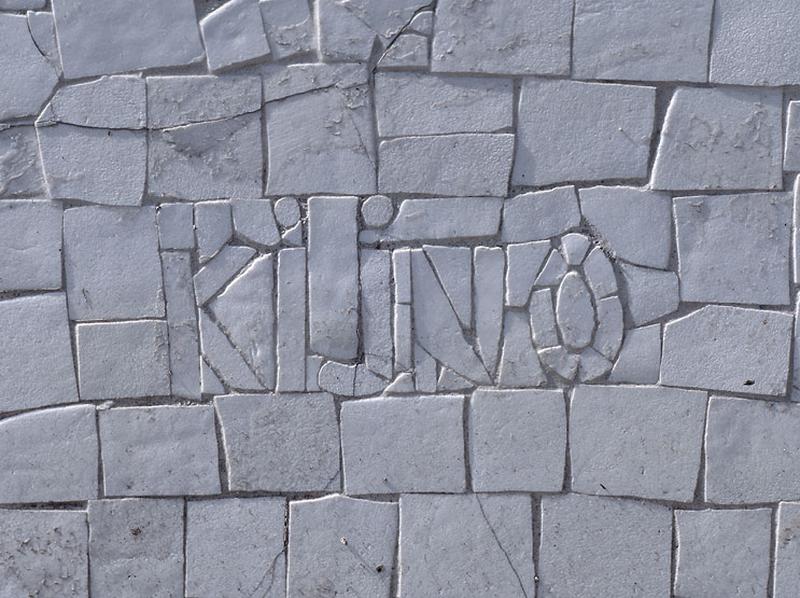 Détail de la mosaïque couvrant le pignon Ouest du gymnase : signature du cartonnier.