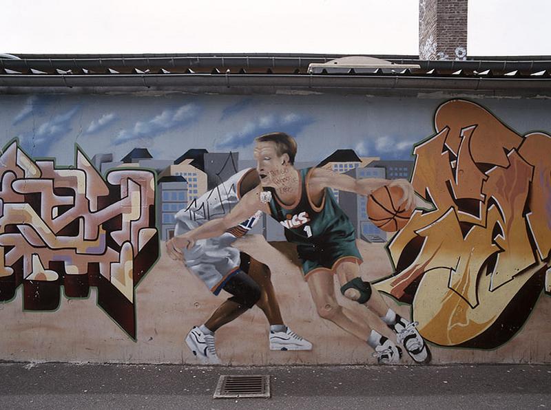 Détail de la peinture couvrant le mur Nord du bas-côté du gymnase de l'atelier Label Decadix.