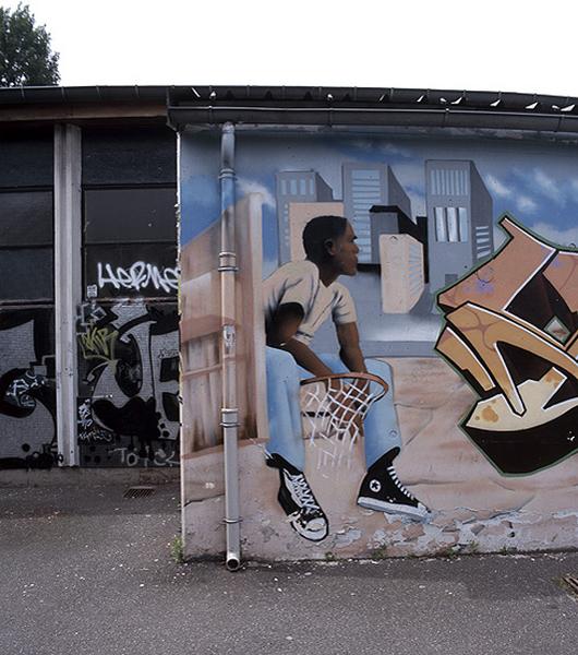 Détail de la peinture couvrant le mur Nord du bas-côté du gymnase de l'atelier Label Decadix.