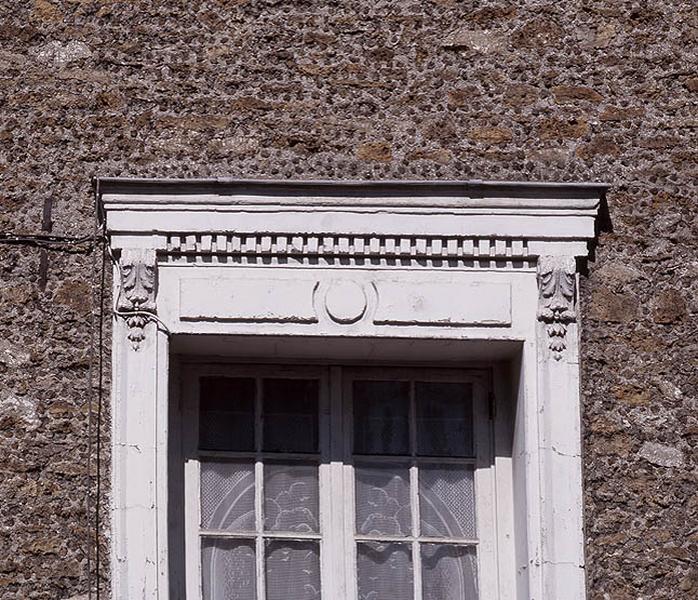 Décor en bas-relief de stuc contribuant à la modénature de la façade.