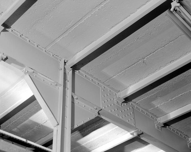 Intérieur du bâtiment de 'stockage du matériel'. Rez-de-chaussée : structure métallique, soutenant le plancher du premier étage, installée après la construction des murs à pans de bois hourdés de brique.