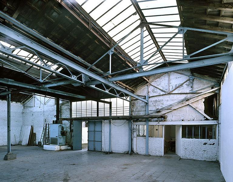 L'intérieur de l'usine, depuis l'emplacement des anciens fours. A droite, l'emplacement de l'atelier d'ébarbage ; au milieu, l'aire de coulée ; à gauche, le long du mur, étaient entreposés, par tailles, les châssis des moules.