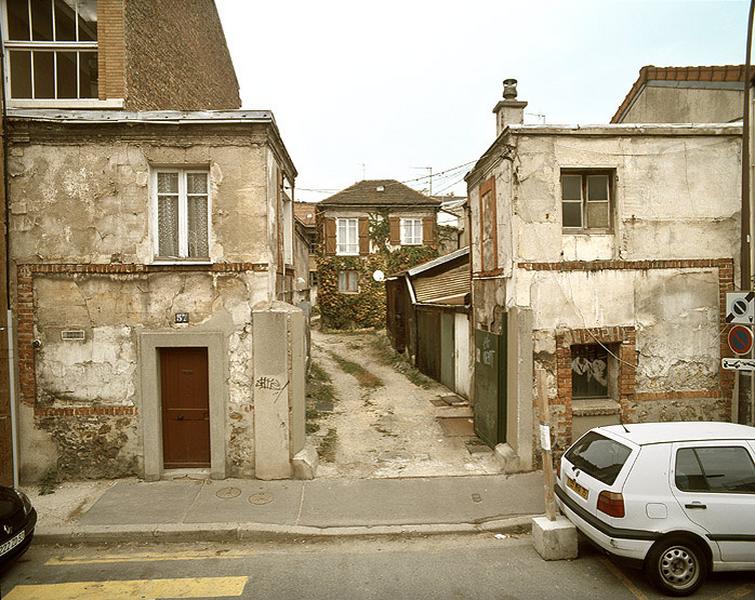 L'entrée de l'ancienne parcelle agricole en lanière est marquée par deux pavillons à un étage, en matériaux traditionnels : moellons de gypse et enduit de plâtre.