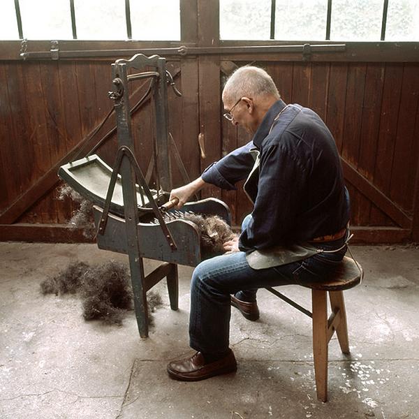 M. *, qui a fait son apprentissage dans l'atelier de tapisserie, restitue quelques gestes du travail. La cardeuse à main ou balancelle permet d'ouvrir le crin, destiné par exemple à uniformiser le fond d'un fauteuil.
