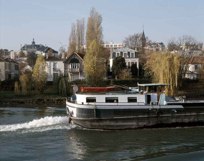 Les quais de la Marne entre la mairie et l'église, péniche au premier plan.