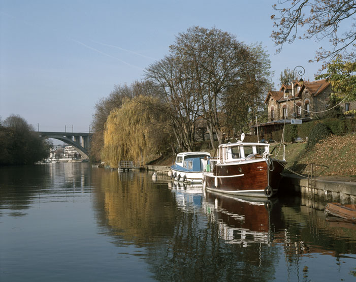 Les quais de la Marne, bateaux au premier plan, au loin le viaduc.