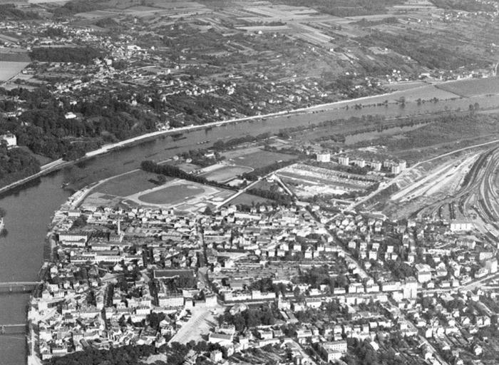 Vue aérienne de la rive sud, détail : la partie sud-est de la commune, avec le stade. On reconnaît également l'usine Baummann. Le site de la Cooper n'est pas encore occupé par l'usine actuelle. Le pont du Général Leclerc n'est pas encore reconstruit.