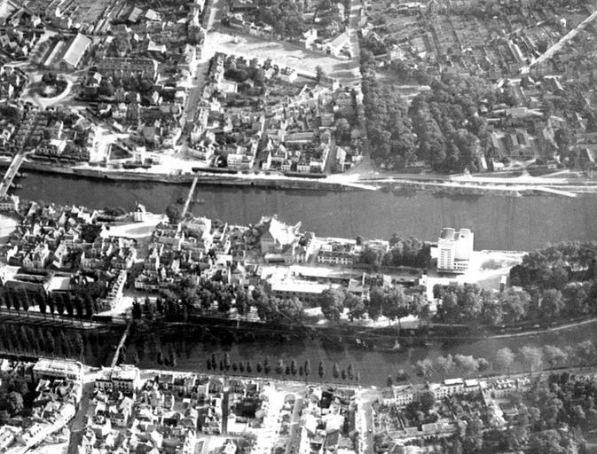 Vue aérienne de l'île Saint-Etienne et de la rive sud, détail de la partie ouest. On reconnaît les silos, les Moulins, la poste, et sur la rive sud, les abattoirs. Les ponts Jeanne d'Arc et du Général Leclerc ne sont pas encore reconstruits.