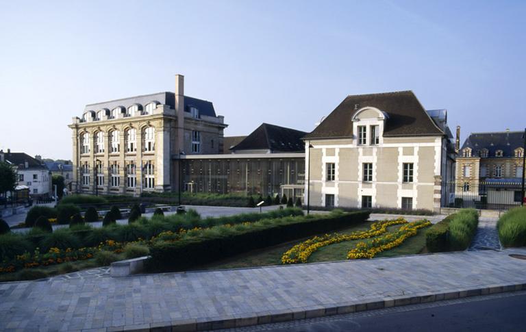 La façade : vue d'ensemble. Le hall en verre de Reichen et Robert (2000) relie le bâtiment des archives (1893), à gauche, au pavillon néo-classique (1969), à droite. Dans le fond à droite apparaît l'hôtel du préfet.