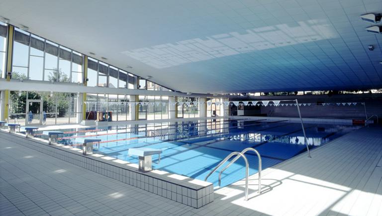 La piscine couverte : vue intérieure. Le grand bassin et ses plongeoirs.