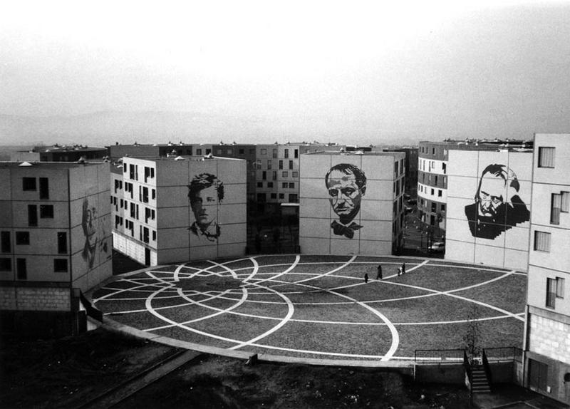 Vue d'ensemble de la place de la Coquille. Elle aurait du abriter d'un côté un bâtiment courbe et bas destiné à la mairie qui aurait fait face aux murs pignons ornés des portaits d'hommes de lettres du XIXe siècle. Ici de gauche à droite Paul Valéry, Arthur Rimbaud, Baudelaire et Victor Hugo. Le sol de la place comprend un tracé en marbre blanc dessiné par Ewa Brukalska, évoquant celui de la place du Capitole à Rome.