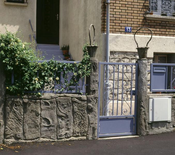 Clôture en ciment de type rustique imitant le bois, 13 rue Louise.