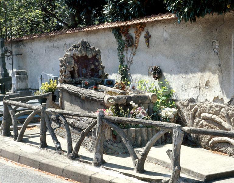 Vue d'ensemble de la tombe et de son enclos tout en ciment faux-bois, bel exemple d'architecture rustique.