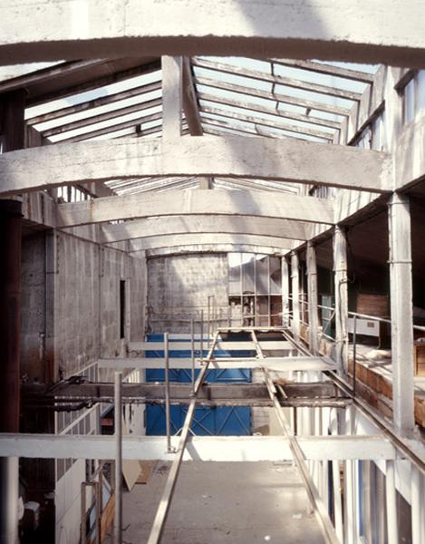 Vue intérieure d'un bâtiment, détail de la structure en béton sous une verrière.