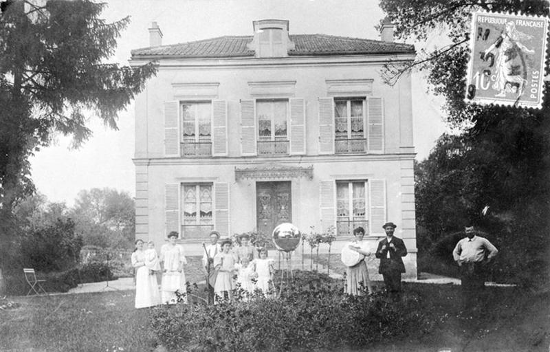 Vue d'une famille posant devant une villa (1909).