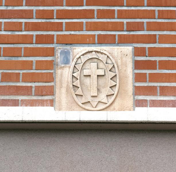 Détail de la croix de saint Camille sur une façade.