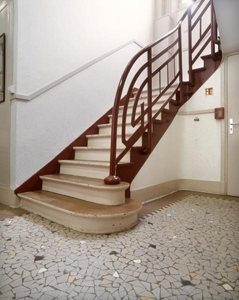 Détail d'un départ d'escalier intérieur. Le sol en 'carrelage cassé' est d'origine.
